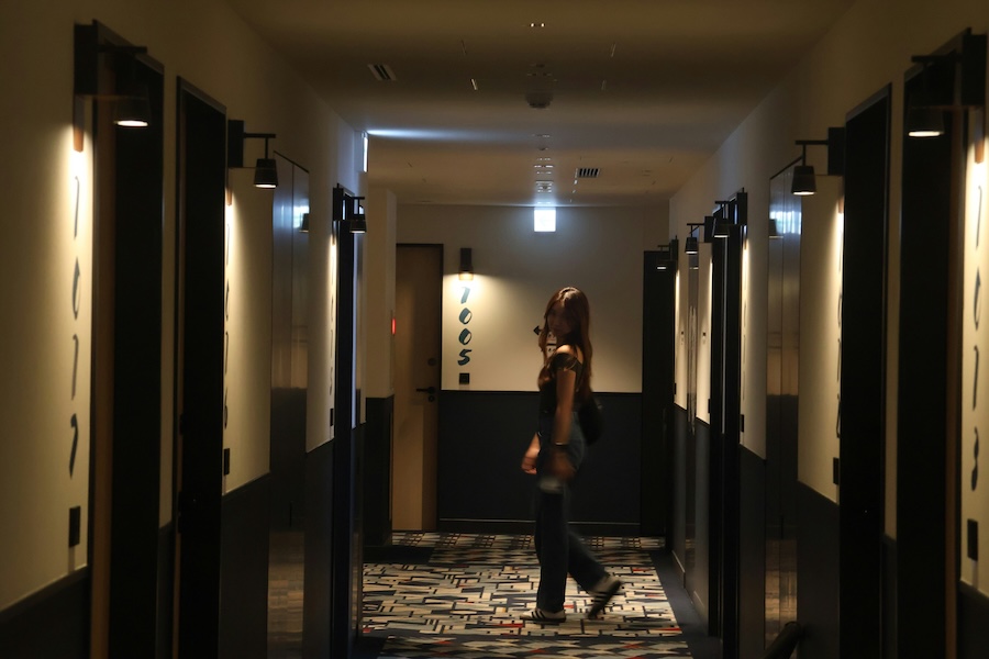 A young woman in the corridor of a Japanese hotel.